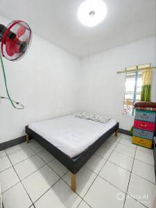 a bedroom with a bed and a fan on the wall at Tiga Dara Homestay 3 in Pangandaran
