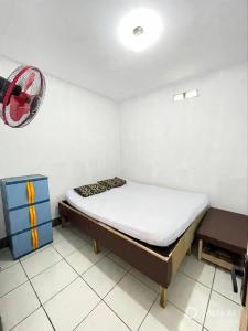 a small bedroom with a bed and a fan at Tiga Dara Homestay 3 in Pangandaran