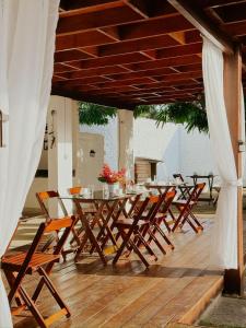 a wooden table and chairs on a wooden deck at Pousada da Mangueira 1 in Barreirinhas