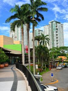 a city street with palm trees and buildings at Abreeza place T-2 in Davao City