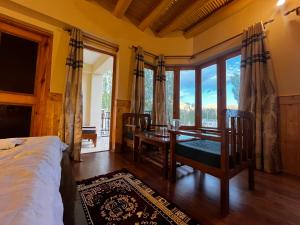 a bedroom with a bed and a table and chairs at Zaltak Guest House and Hostel in Leh
