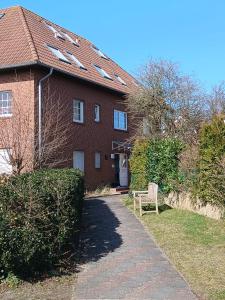 a brick house with a bench in front of it at Ferienwohnung Uns Huus in Langeoog