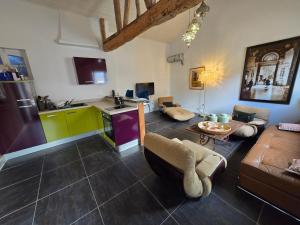 a kitchen and living room with a couch and a table at Gîte, jacuzzi et piscine in Cintegabelle