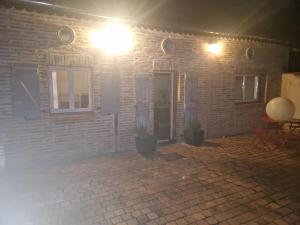 a brick building with potted plants in front of it at Gîte, jacuzzi et piscine in Cintegabelle