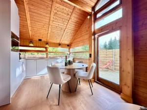 eine Küche und ein Esszimmer mit Tisch und Stühlen in der Unterkunft Chalet Marron in Durbuy
