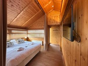 ein Schlafzimmer mit einem großen Bett in einem Holzhaus in der Unterkunft Chalet Marron in Durbuy