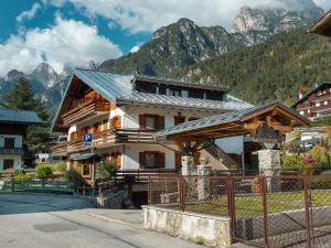a building with mountains in the background at Appartamenti Leovacanze in Auronzo di Cadore