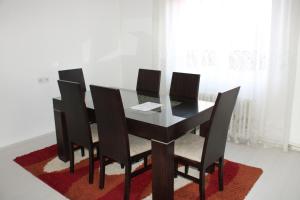 a black dining room table with four chairs on a rug at House Stoevi in Negotino
