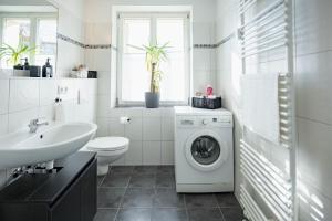 a bathroom with a washing machine and a sink at Central Station Apartment in Dessau +21 photos
