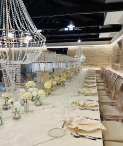 a long banquet hall with white tables and chairs at Il Casale della Baronessa in Palmi