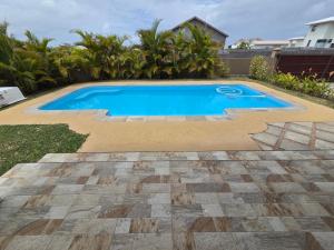 a swimming pool in the backyard of a house at Skyra Villa in Mahébourg
