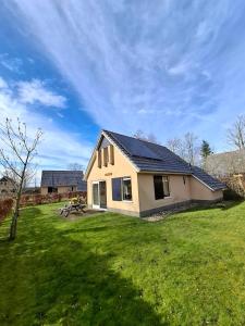 a small house in a yard with a green lawn at 't Sinnehûs in Sondel
