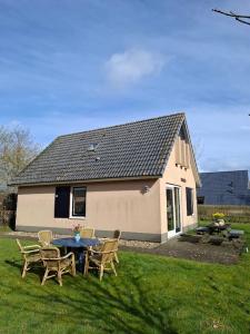 a house with a table and chairs in the yard at 't Sinnehûs in Sondel