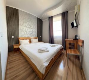 a bedroom with a large bed with white sheets at Гостиница Балхаш in Balqash
