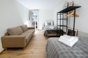 a living room with a couch and a bed at 5 room apartment for 8 people at Bergcafe Aurora Lenzerheide in Lenzerheide