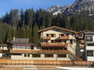 a large building with a mountain in the background at 5 room apartment for 8 people at Bergcafe Aurora Lenzerheide in Lenzerheide