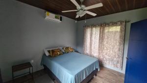 a bedroom with a blue bed and a ceiling fan at House with a private pool in Ojochal +26 photos