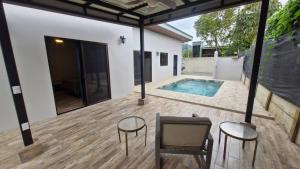 a patio with a pool and two chairs and a table at House with a private pool in Ojochal