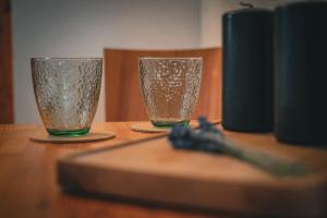 two glasses sitting on top of a wooden table at Haus am Stausee in Altenbeuthen