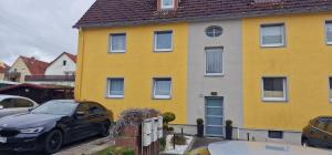 a yellow house with a black car parked in front at Bartol in Immendingen