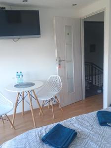 a room with a table and chairs and a tv at Noclegi u Beaty in Dubiecko