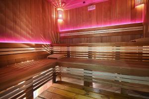 a sauna with wooden benches and pink lights at Hotel Moldavia in Slănic-Moldova