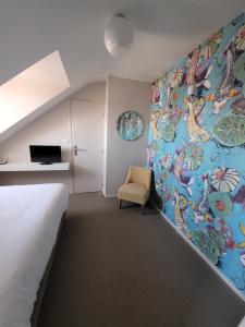 a bedroom with a bed and a painting on the wall at Hôtel Port Haliguen in Quiberon