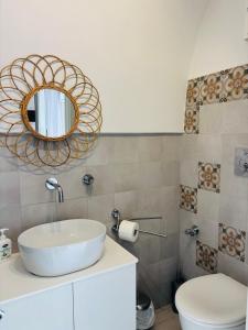 a bathroom with a sink and a mirror and a toilet at Affittacamere Nalì in Polignano a Mare
