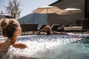Eine Frau liegt in einem Schwimmbecken in der Unterkunft ARPURIA - 4 Star Superior - Adults Only in Sankt Anton am Arlberg