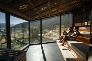 zwei Personen sitzen mit einem Laptop auf einem Balkon in der Unterkunft ARPURIA - 4 Star Superior - Adults Only in Sankt Anton am Arlberg