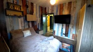 a bedroom with a bed and a flat screen tv at Nayri HOUSE Самоков,село Доспей in Dospey