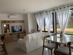 a living room with a white couch and a table at Casa 6 personas con piscina en Piriápolis Playa los Angeles in Piriápolis