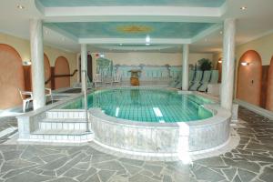 a swimming pool in a building with a pool at Gräfliches Hotel Alte Post in Bad Birnbach