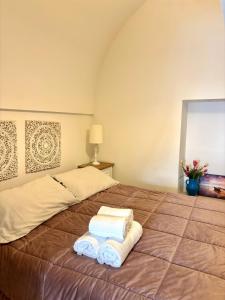 a bed with three towels on top of it at Affittacamere Nalì in Polignano a Mare +7 photos