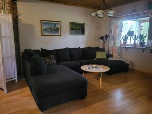 a living room with a black couch and a table at Helt hus i lilla Vuotner in Arvidsjaur