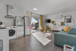 a kitchen and a living room with a blue couch at Le Mas du Soleil in Sainte-Maxime