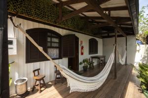 a hammock on the porch of a house at Pousada Bob Pai & Bob Filho in Ilha do Mel