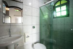 a bathroom with a sink and a glass shower at Pousada Bob Pai & Bob Filho in Ilha do Mel