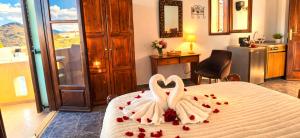 two white swans are sitting on a bed with hearts at Knossos Skynest in Palekastron
