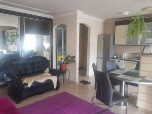 a living room with a black leather couch and a table at Elaktra Apartman in Szolnok
