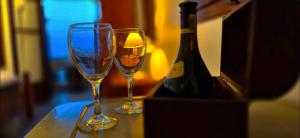 two wine glasses sitting on a table next to a bottle of wine at Knossos Skynest in Palekastron