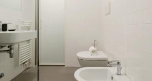 a white bathroom with a toilet and a sink at Modern Apartment between Como & Milan in Lomazzo +24 photos