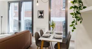 a dining room with a table and chairs and a couch at Modern Apartment between Como & Milan in Lomazzo