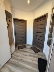 a hallway with two doors and mats on the floor at ROYAL homes in Nesvady +40 photos