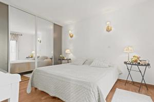 a white bedroom with a bed and a mirror at Le Mas du Soleil in Sainte-Maxime +128 photos