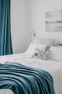 a white bed with a blue blanket on it at Domus Silvana Apartments in Ravenna