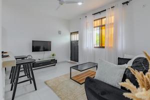 a living room with a couch and a table at Wendy's Da-Azizi Homes Diani 2 in Diani Beach