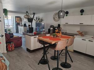 a kitchen with a table and a living room at Chez Mimi et Mimine in Lons-le-Saunier