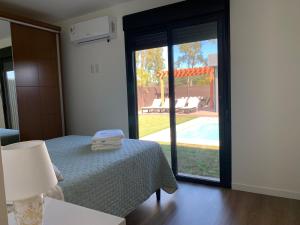 a bedroom with a bed and a view of a pool at Casa 6 personas con piscina en Piriápolis Playa los Angeles in Piriápolis +7 photos