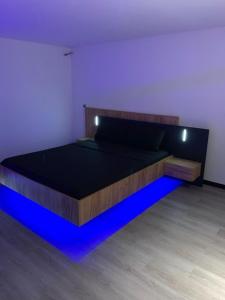 a bedroom with a bed with blue lights on it at Sanu Home B&B in Lonate Pozzolo